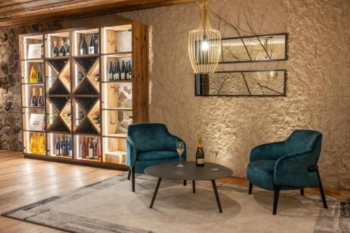 two chairs and a table in a room with wine bottles at Villa Carolina in Selva di Val Gardena