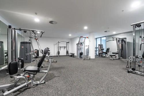- une salle de sport avec plusieurs tapis de course et appareils de cardio-training dans l'établissement New & Modern Loft 1bd w/Pool&Gym, à Canberra