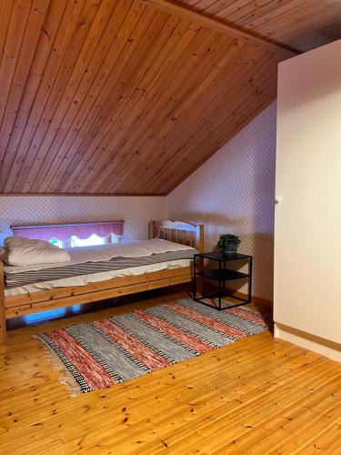 - une chambre avec un lit et un plafond en bois dans l'établissement Trevlig villa mellan sjöarna i Vistträsk By., à Vistheden