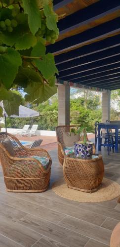un patio con 2 sillas de mimbre y una maceta en Sondela Self Catering, en São Martinho do Porto