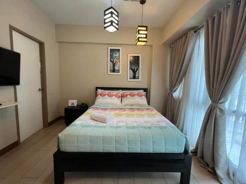 a bedroom with a bed and a large window at Palm Tree Two Villas in Manila