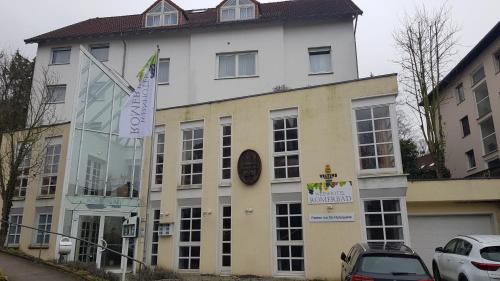 a large white building with cars parked in front of it at Weinhotel Römerbad in Bad Salzuflen