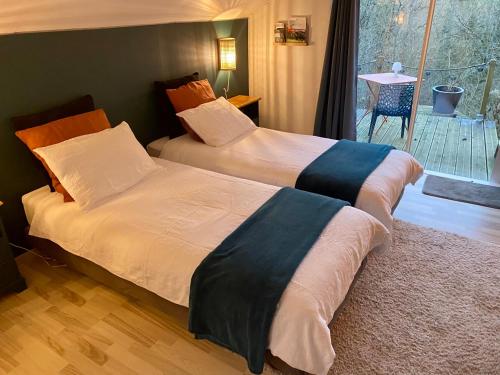 two beds sitting next to each other in a bedroom at la chambre d hotes de marie indépendante et sa terrasse avec vue panoramique proche alpes mancelles in Sillé-le-Guillaume