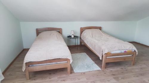 two beds sitting next to each other in a room at Agro House Mezge - აგროსახლი მეზგე in Bashkʼo