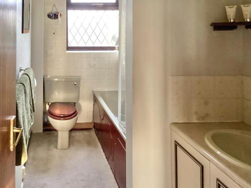 a bathroom with a toilet and a sink at Lakeland Bungalow in Oulton