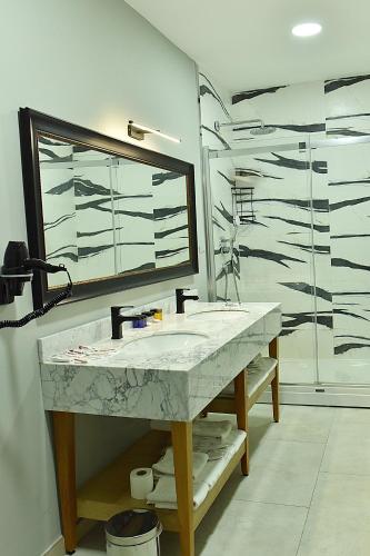 a bathroom with a sink and a mirror and a shower at Kerthill Hotel in Istanbul