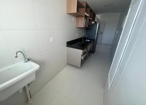 a small white bathroom with a sink and a sink at Mana beach 2 quartos Muro Alto Ipojuca in Ipojuca