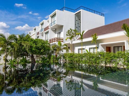 een gebouw met een zwembad ervoor bij Lynnaya Urban River Resort in Siem Reap