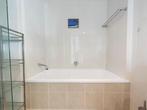 a white bath tub in a bathroom with a shower at Stunning view close to everything in Gold Coast