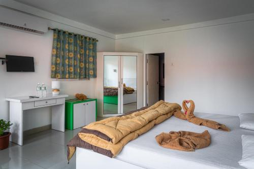 Un dormitorio con una cama grande con una manta. en Palolem Beach Resort, en Palolem