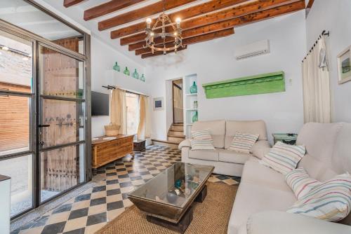 ein Wohnzimmer mit einem Sofa und einem Tisch in der Unterkunft La Sastrería in Pollença
