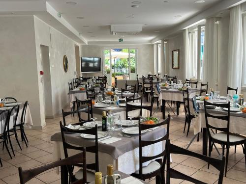 un comedor con mesas y sillas en un restaurante en Hotel Monti, en Riccione