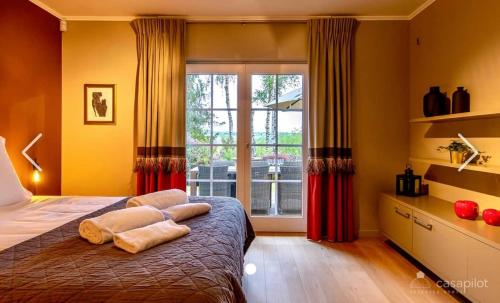 1 dormitorio con cama y ventana grande en Côté Mont en Malmedy