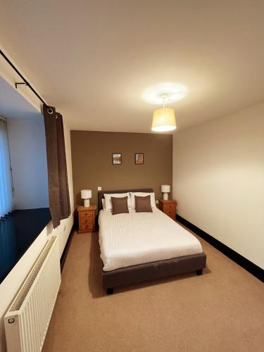a bedroom with a bed and a television in it at Stable Cottage in Ross on Wye