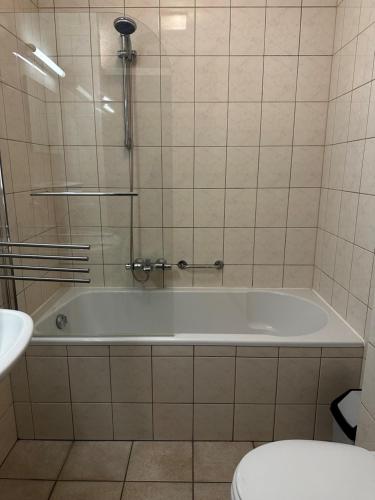 a white bath tub in a bathroom with a toilet at Recreatiebungalow Lochem in Lochem