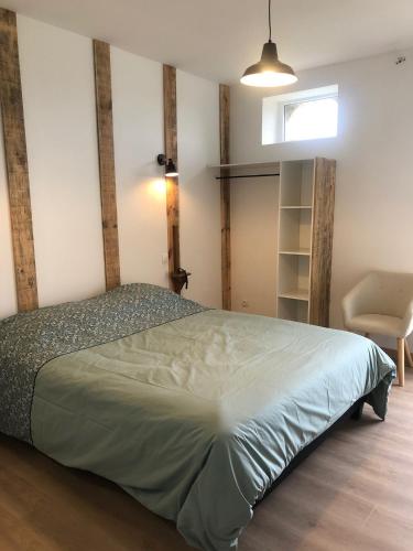 une chambre avec un lit et une chaise dedans dans l'établissement Chambres d’hôtes Arremounon, à Lamothe