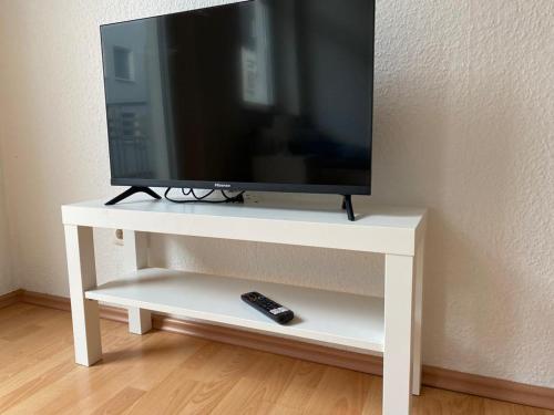 a television on a white stand with a remote control at ***Übernacht24*** Zentrale Wohnung in Gelsenkirchen in Gelsenkirchen