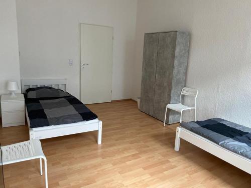 a room with two beds and two chairs in it at ***Übernacht24*** Zentrale Wohnung in Gelsenkirchen in Gelsenkirchen