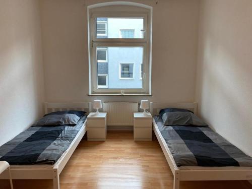 two beds in a room with a window at ***Übernacht24*** Zentrale Wohnung in Gelsenkirchen in Gelsenkirchen