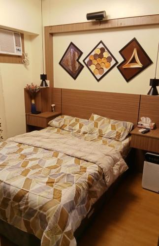 a bedroom with a large bed and some pictures on the wall at Joey's Place Calathea DMCI in Manila