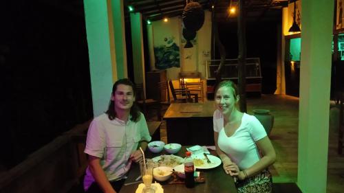 a man and a woman sitting at a table with food at Gems Garden Guest House in Tangalle