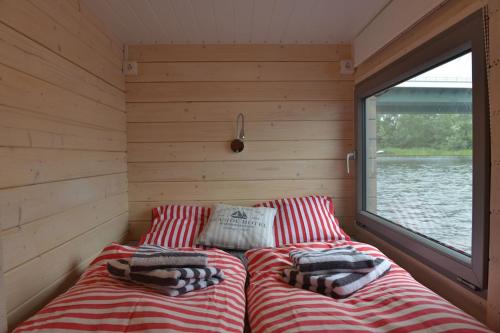 a bed in the corner of a room with a window at Hausboot NautikHus auf der Havel in Kolonie Zern