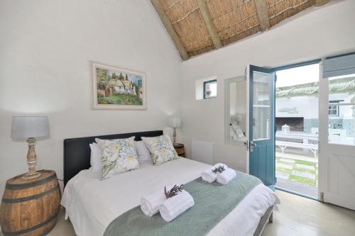 1 dormitorio con 1 cama con toallas en Zuidste Huisie Fisherman's Cottage, en Struisbaai