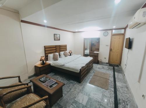 a bedroom with a bed and a table and a chair at Lexus Lodge in Islamabad