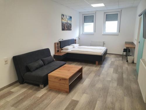 a living room with a couch and a bed at Hotel FeWo-HM in Ramstein-Miesenbach