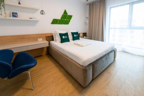 1 dormitorio con 1 cama y 1 silla azul en Smart Concept Living Plaza, en Bucarest