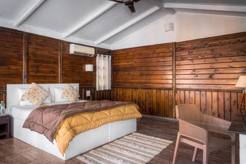 1 dormitorio con 1 cama y pared de madera en Cuba Patnem, en Patnem