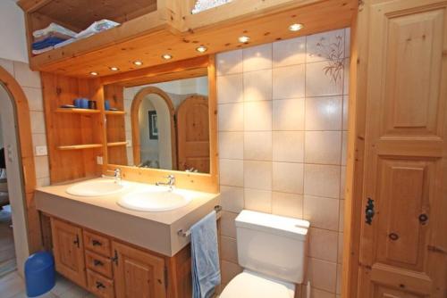 a bathroom with two sinks and a toilet and a mirror at Chesa Sonnenuhr in Madulain