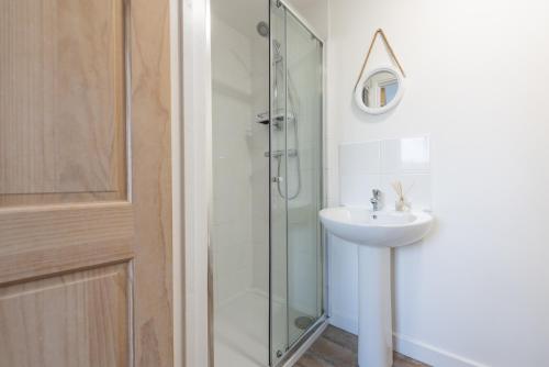 a bathroom with a sink and a glass shower at Wheal Amelia- Beautifully Fitted Wooden Lodge Helston Cornwall in Helston