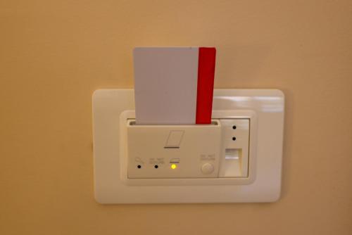 un interruptor de luz blanco con una tarjeta roja. en Brettia Guest Rooms, en Cosenza