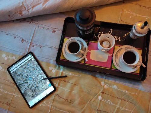 a tray with cups of coffee and a tablet on a table at Irini's Home - Pitsidia in Pitsidia
