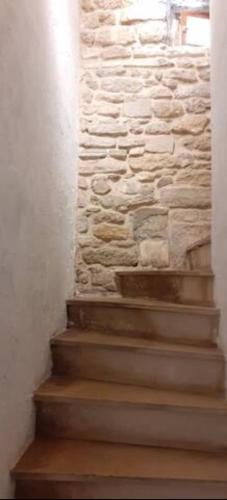 a stairway with a stone wall and some stairs at Appartement LE COURS in Barbentane