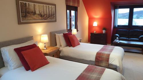 a hotel room with two beds and a chair at Loch View, Lairg in Lairg