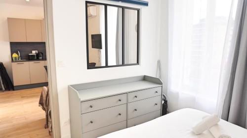 een slaapkamer met een witte dressoir en een spiegel bij Centre Cannes, Appartement 301, 1 room By Palmazur in Cannes