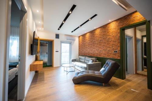 a living room with a couch and a brick wall at DMS Apartments & Suites Sarajevo in Vogošća