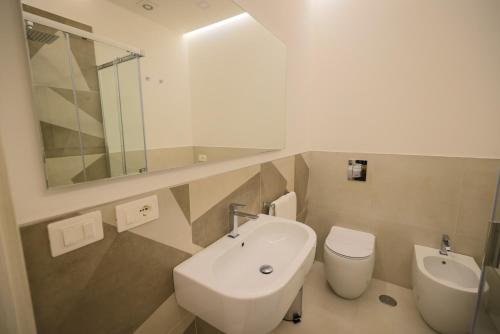La salle de bains est pourvue d'un lavabo, de toilettes et d'un miroir. dans l'établissement Brettia Guest Rooms, à Cosenza