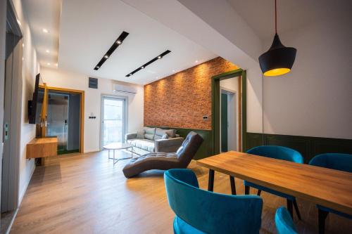 a living room with a table and blue chairs at DMS Apartments & Suites Sarajevo in Vogošća