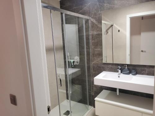 a bathroom with a glass shower and a sink at ROMERO APARTMENTS SUNSET CLIFFS BENIDORM in Benidorm
