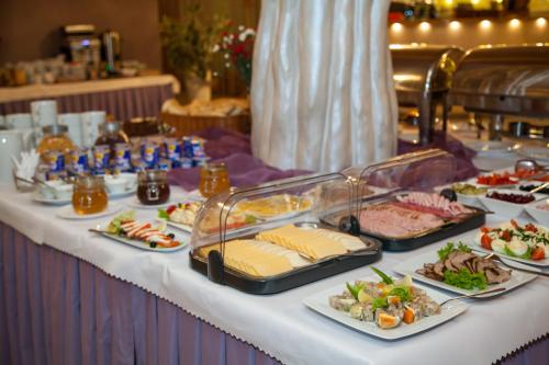 a buffet of food on a table with plates of food at Hotel IKAR in Bydgoszcz