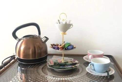 a tea kettle and cups on a glass table at Landlust Unser L ieblingscafe in Xanten