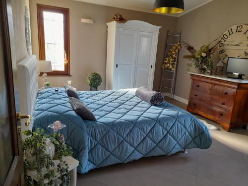 a bedroom with a blue bed and a wooden dresser at L'antica Fornace di Barale Emanuela in Vicoforte