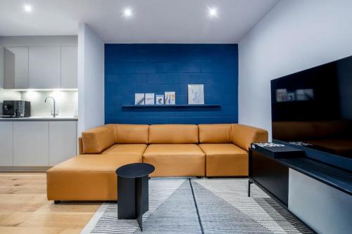 a living room with a brown couch and a blue wall at Free Parking - Roof Terrace - Luxury Townhouse in Manchester