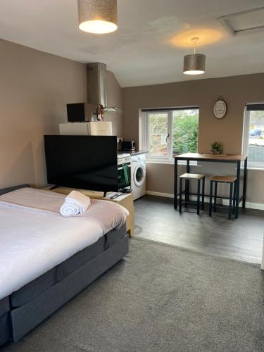 a bedroom with a bed and a kitchen with a table at Annex - Garden View in Bristol