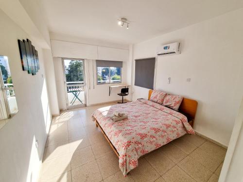a bedroom with a bed with a red bedspread at City View Rooms in Larnaka