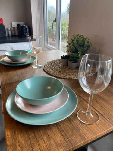 einem Holztisch mit zwei Tellern und Gläsern darauf in der Unterkunft Annex - Garden View in Bristol