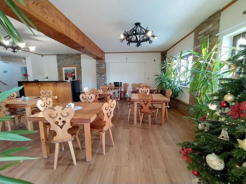 a dining room with wooden tables and chairs and a christmas tree at Chochołowskie Zacisze przy Termach - Apartamenty i Pokoje in Chochołów